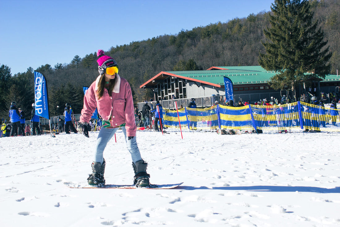 Snowboarder wearing jeans on snowboard