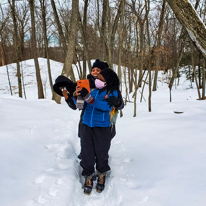 2 hikers taking selfies in a snowy forest