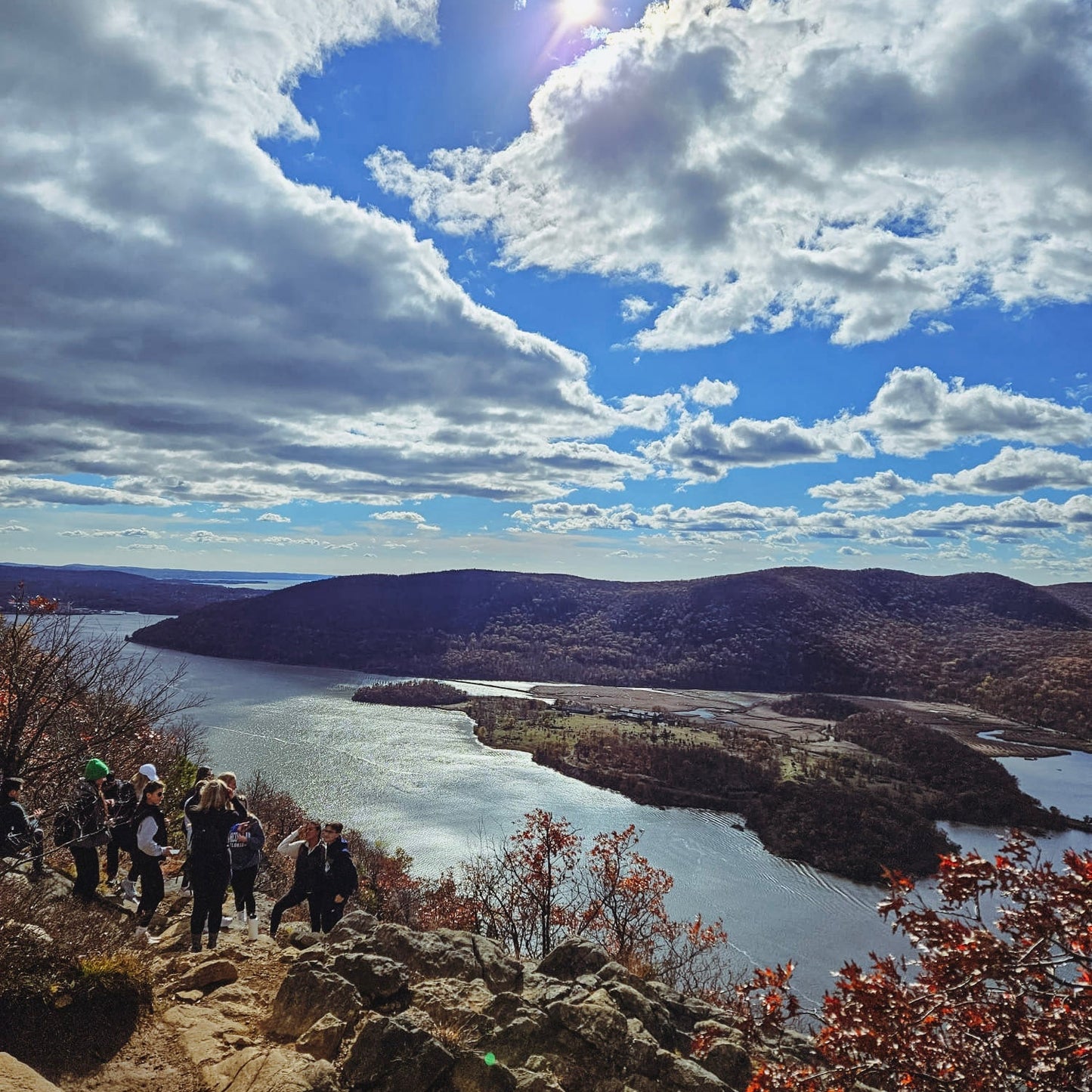 Scenic view of Hudson river from a high vantage point with people on a rocky path.